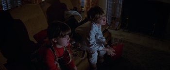 Movie still from “Halloween” (1978), directed by John Carpenter – Two young children are playing a video game together; Medium shot, High angle