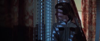 Movie still from “Halloween” (1978), directed by John Carpenter – A young boy standing in front of a window; Medium shot, Low angle