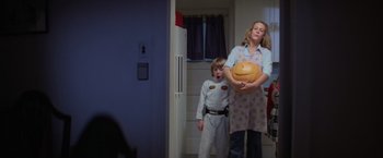 Movie still from “Halloween” (1978), directed by John Carpenter – A woman and a boy holding a pumpkin in a kitchen; Medium shot, Low angle