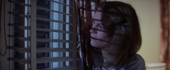 Movie still from “Halloween” (1978), directed by John Carpenter – A woman looking out of a window at night; Close Up shot, Low angle