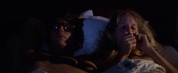 Movie still from “Halloween” (1978), directed by John Carpenter – A man and a woman sitting next to each other in bed; Medium shot, High angle