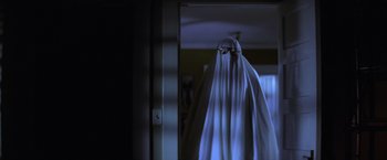 Movie still from “Halloween” (1978), directed by John Carpenter – A person with a white sheet over their face; Medium shot, Low angle