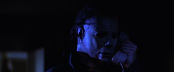Movie still from “Halloween” (1978), directed by John Carpenter – A person wearing a mask on a cell phone; Close Up shot, Low angle