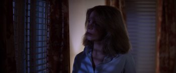 Movie still from “Halloween” (1978), directed by John Carpenter – A woman in a white shirt is standing in a room; Close Up shot, Low angle