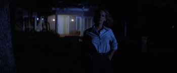 Movie still from “Halloween” (1978), directed by John Carpenter – A woman standing in the dark in front of a house; Medium shot, Low angle