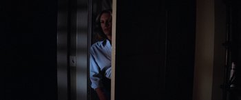 Movie still from “Halloween” (1978), directed by John Carpenter – A woman standing in front of an open door; Medium shot, Over the shoulder angle