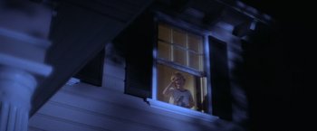 Movie still from “Halloween” (1978), directed by John Carpenter – A person standing in a window at night; Wide shot, Low angle