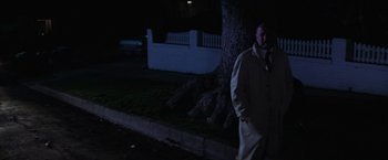 Movie still from “Halloween” (1978), directed by John Carpenter – A man standing next to a tree at night; Wide shot, Low angle