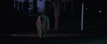 Movie still from “Halloween” (1978), directed by John Carpenter – A man in a trench coat walking down a street; Wide shot, Low angle