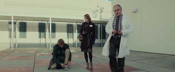 Movie still from “Halloween” (2018), directed by David Gordon Green – A man and a woman and a man with a tie; Wide shot, Low angle