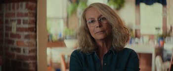 Movie still from “Halloween” (2018), directed by David Gordon Green – An older woman with long blonde hair wearing glasses; Close Up shot, Low angle