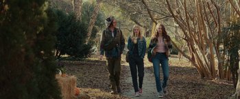 Movie still from “Halloween” (2018), directed by David Gordon Green – A group of people walking down a path in the woods; Wide shot, Low angle