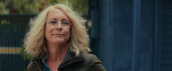 Movie still from “Halloween” (2018), directed by David Gordon Green – An older woman wearing glasses and a jacket; Close Up shot, Low angle