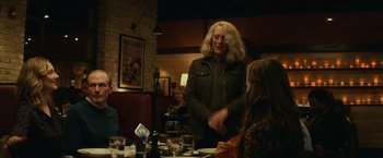 Movie still from “Halloween” (2018), directed by David Gordon Green – A woman is shaking hands with a woman at a restaurant; Medium shot, Over the shoulder angle