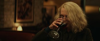 Movie still from “Halloween” (2018), directed by David Gordon Green – A woman drinking a glass of wine in a restaurant; Close Up shot, High angle