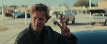 Movie still from “Halloween” (2018), directed by David Gordon Green – A person holding up a peace sign; Close Up shot, Over the shoulder angle