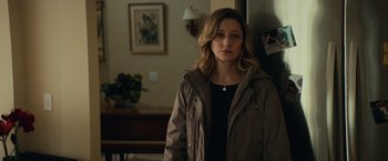 Movie still from “Halloween” (2018), directed by David Gordon Green – A woman standing in front of a wall in a living room; Medium shot, Over the shoulder angle