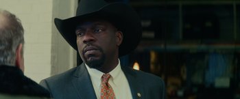 Movie still from “Halloween” (2018), directed by David Gordon Green – A man wearing a suit and a hat; Close Up shot, Low angle