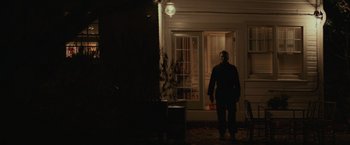 Movie still from “Halloween” (2018), directed by David Gordon Green – A man standing in front of a door at night; Wide shot, Low angle