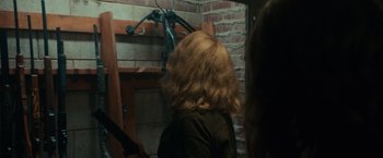 Movie still from “Halloween” (2018), directed by David Gordon Green – A woman with blonde curly hair standing in front of a brick wall; Medium shot, Over the shoulder angle