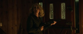 Movie still from “Halloween” (2018), directed by David Gordon Green – A woman holding a gun in a dark room; Medium shot, Low angle