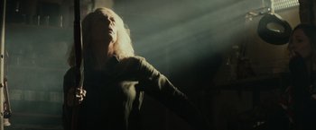 Movie still from “Halloween” (2018), directed by David Gordon Green – A woman with long blonde hair standing in a dark room; Medium shot, Low angle