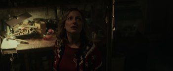 Movie still from “Halloween” (2018), directed by David Gordon Green – A woman in a red shirt looking up at the ceiling; Medium shot, Over the shoulder angle