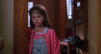 Movie still from “Halloween 4: The Return of Michael Myers” (1988), directed by Dwight H. Little – A young girl wearing a pink jacket standing next to a wooden pole; Close Up shot, High angle