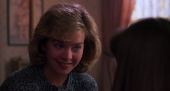 Movie still from “Halloween 4: The Return of Michael Myers” (1988), directed by Dwight H. Little – A young woman with blonde hair and blue eyes smiling for the camera; Close Up shot, Over the shoulder angle