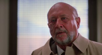 Movie still from “Halloween 4: The Return of Michael Myers” (1988), directed by Dwight H. Little – An older man with a beard wearing a jacket and a tie; Close Up shot, Low angle