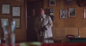 Movie still from “Halloween 4: The Return of Michael Myers” (1988), directed by Dwight H. Little – A man standing in front of a door way; Medium shot, Low angle