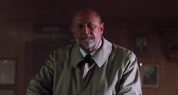 Movie still from “Halloween 4: The Return of Michael Myers” (1988), directed by Dwight H. Little – An older man wearing a jacket and a tie; Close Up shot, Low angle