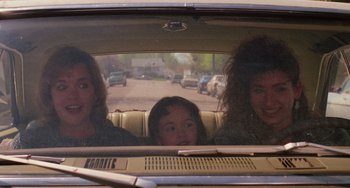 Movie still from “Halloween 4: The Return of Michael Myers” (1988), directed by Dwight H. Little – Three young girls in the back seat of a car; Medium shot, Over the shoulder angle