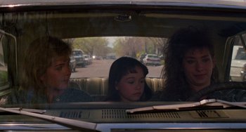 Movie still from “Halloween 4: The Return of Michael Myers” (1988), directed by Dwight H. Little – A group of people sitting in the back of a car; Medium shot, Over the shoulder angle