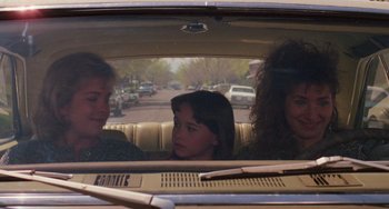 Movie still from “Halloween 4: The Return of Michael Myers” (1988), directed by Dwight H. Little – Three women in the back seat of a car looking out the window; Medium shot, Over the shoulder angle