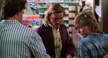 Movie still from “Halloween 4: The Return of Michael Myers” (1988), directed by Dwight H. Little – A group of young men standing around in a store; Medium shot, Over the shoulder angle