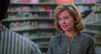Movie still from “Halloween 4: The Return of Michael Myers” (1988), directed by Dwight H. Little – A young woman in a gray sweater in a store; Close Up shot, Over the shoulder angle