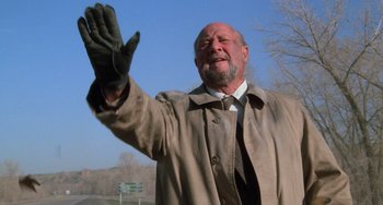 Movie still from “Halloween 4: The Return of Michael Myers” (1988), directed by Dwight H. Little – An older man wearing a coat and tie waving; Medium shot, Low angle