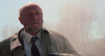 Movie still from “Halloween 4: The Return of Michael Myers” (1988), directed by Dwight H. Little – An older man with a beard and a tie; Close Up shot, Low angle