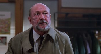 Movie still from “Halloween 4: The Return of Michael Myers” (1988), directed by Dwight H. Little – An older man with a beard wearing a jacket and a tie; Close Up shot, Low angle