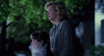 Movie still from “Halloween 4: The Return of Michael Myers” (1988), directed by Dwight H. Little – A woman standing next to a little girl in front of a tree; Medium shot, Over the shoulder angle