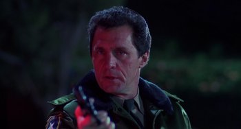 Movie still from “Halloween 4: The Return of Michael Myers” (1988), directed by Dwight H. Little – A person holding a gun; Close Up shot, Low angle