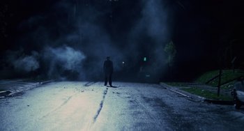 Movie still from “Halloween 4: The Return of Michael Myers” (1988), directed by Dwight H. Little – A man standing on the side of a road at night; Wide shot, Low angle