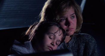 Movie still from “Halloween 4: The Return of Michael Myers” (1988), directed by Dwight H. Little – A woman and a child sleeping next to each other in front of a computer screen; Close Up shot, Low angle