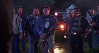 Movie still from “Halloween 4: The Return of Michael Myers” (1988), directed by Dwight H. Little – A group of men walking down a street holding guns; Medium shot, Low angle