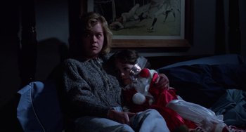 Movie still from “Halloween 4: The Return of Michael Myers” (1988), directed by Dwight H. Little – A woman sitting next to a child on a couch; Medium shot, High angle