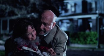 Movie still from “Halloween 4: The Return of Michael Myers” (1988), directed by Dwight H. Little – An older man and a young woman embracing each other; Close Up shot, Over the shoulder angle