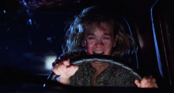 Movie still from “Halloween 4: The Return of Michael Myers” (1988), directed by Dwight H. Little – A woman is driving a car at night; Close Up shot, Low angle