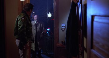 Movie still from “Halloween 4: The Return of Michael Myers” (1988), directed by Dwight H. Little – Two men are standing in front of a mirror; Medium shot, Over the shoulder angle