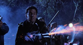 Movie still from “Halloween 5: The Revenge of Michael Myers” (1989), directed by Dominique Othenin-Girard – A man holding a gun with a bunch of sparks coming out of it; Close Up shot, Low angle